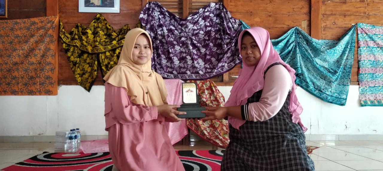 Serah terima plakat UISI dari Ngatini  terhadap Iswatunnajwa, anggota Batik Tehnik Center