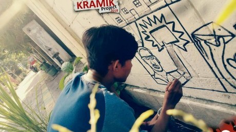 Mahasiswa DKV UISI sedang melukis mural di dinding awikoen tama